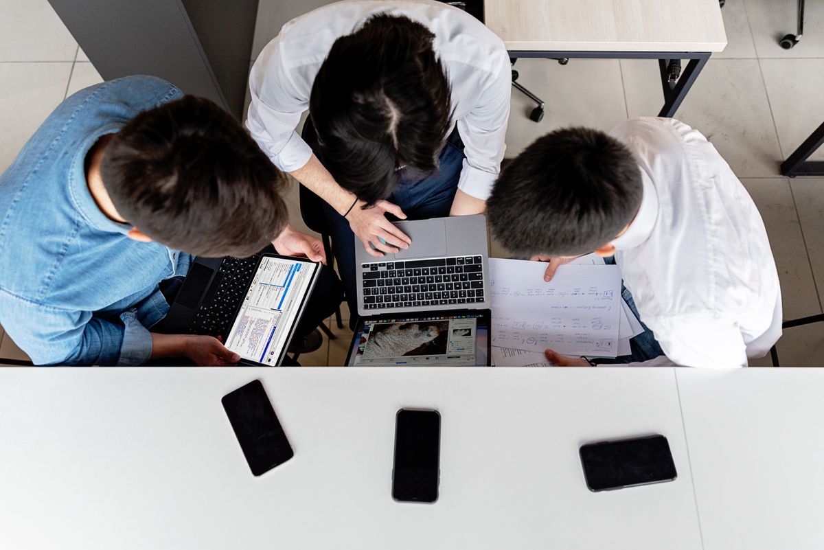 Colleagues planning a technical project with laptops and documents