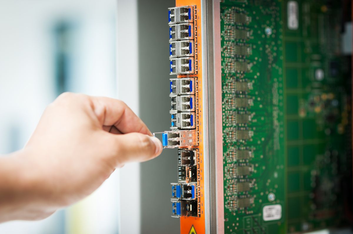Network technician installing and checking cables in a server rack